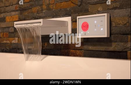 Robinet d'eau numérique moderne, remplissant le bain blanc, mise au point sélective Banque D'Images