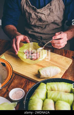 Homme cuisant des rouleaux de chou avec de la viande hachée Banque D'Images