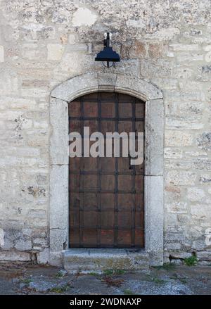 Ancienne porte en bois avec lampadaire sur le mur de briques whit. Vieille porte, porte antique avec la lampe, porte de vieillesse. Banque D'Images