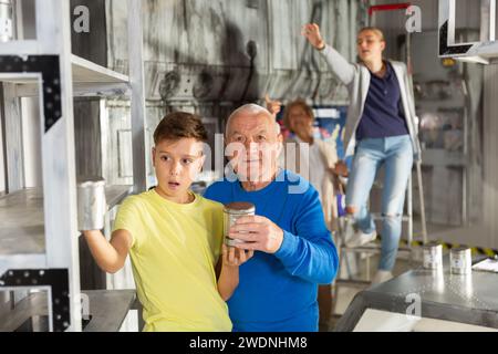 Petits-enfants et grands-parents dans la salle d'évacuation Banque D'Images