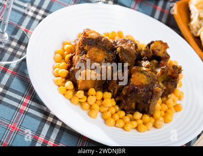 Oxtails braisé avec les pois chiches sur une plaque blanche Banque D'Images