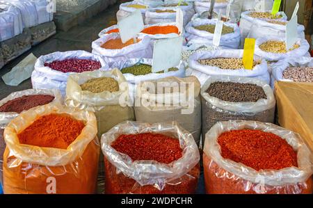 Épices colorées orientales et légumineuses dans de grands sacs vendus à l'extérieur sur un marché Banque D'Images