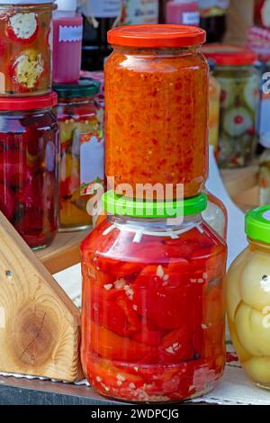 Légumes marinés servis maison bio dans des bocaux en verre vendus à l'extérieur sur un étal de marché Banque D'Images