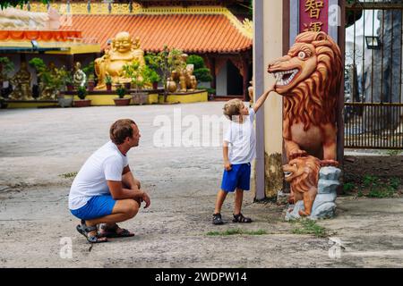 Père et fils touristes marchant dans le temple bouddhiste du Vietnam, enfance heureuse, exploration du monde Banque D'Images