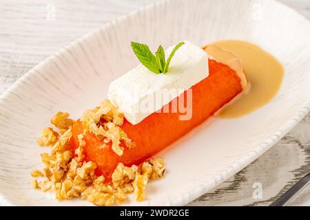 Dessert à la citrouille avec tahini et noix sur une assiette en porcelaine blanche Banque D'Images