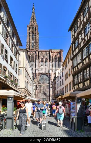 Strasbourg, France - 5 septembre 2023 : rue avec des touristes devant la célèbre cathédrale de Strasbourg en France dans l'architecture romane et gothique Banque D'Images