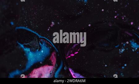 Peinture fluide scintillante renverse de l'encre bleue rose noire Banque D'Images