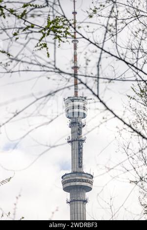 vue de la tour de télévision à travers les branches des arbres. structure antenne-mât en forme de tour sur laquelle sont montées des antennes pour la transmission de télévision par radio Banque D'Images