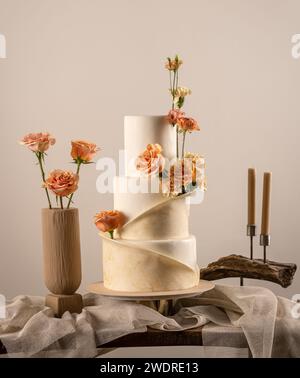 Gâteau de mariage à trois niveaux décoré avec des fleurs de couleur pêche fuzz Banque D'Images