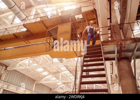 Un homme qui marche dans l'escalier de l'atelier d'ingénierie Banque D'Images