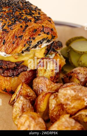hamburger avec patty de bœuf, sauce au fromage sur une assiette avec pommes de terre Banque D'Images