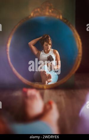 Femme prenant la photo de son reflet dans le miroir Banque D'Images