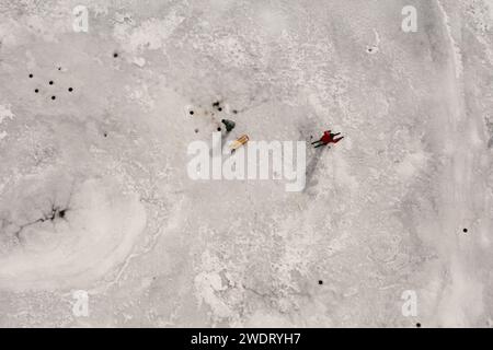 Pêcheurs sur glace et skieurs de fond sur le lac gelé et la glace Banque D'Images