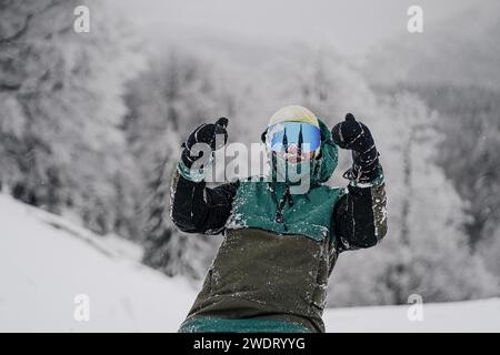 Heureux athlète snowboarder couvert de neige Banque D'Images