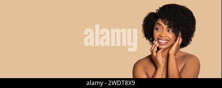 Femme joyeuse avec des cheveux afro naturels souriant sur fond beige, espace copie Banque D'Images