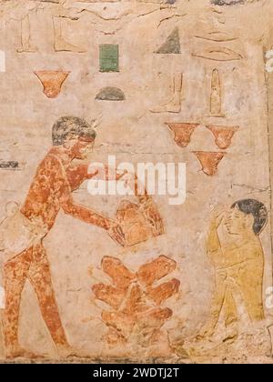 Egypte, Saqqara, tombeau de Ty, scènes de boulangerie : chauffer des pots vides, qui serviront de mini-fours. Protéger le visage de la chaleur, avec le bras. Banque D'Images