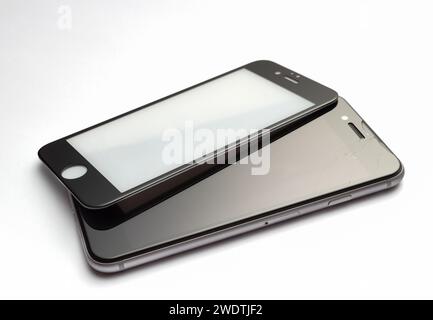 Verre de sécurité pour un smartphone avec un écran cassé sur fond blanc. Banque D'Images