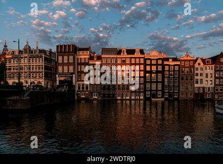 L'heure d'or d'Amsterdam : la lueur chaude du coucher de soleil se reflétant sur les maisons historiques du canal Banque D'Images