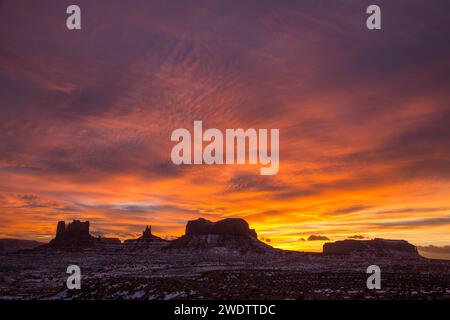 Coucher de soleil coloré sur les monuments de l'Utah dans le Monument Valley Navajo Tribal Park dans l'Utah et l'Arizona. G-R : Château Butte & le Stagecoach, Roi Banque D'Images