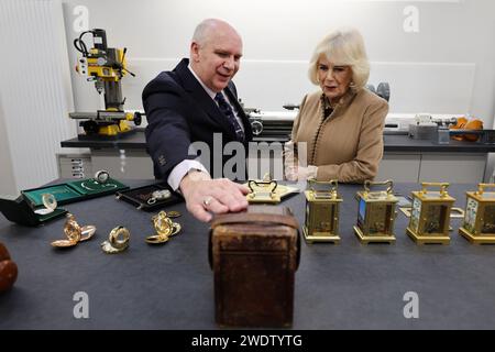 Richard Deacon, directeur général de Deacon & Son's, l'une des plus anciennes entreprises familiales de Swindon, Wilsthire, montre à la reine Camilla un cas utilisé pour une horloge de chariot, alors que l'entreprise célèbre 175 ans de commerce. Date de la photo : lundi 22 janvier 2024. Banque D'Images