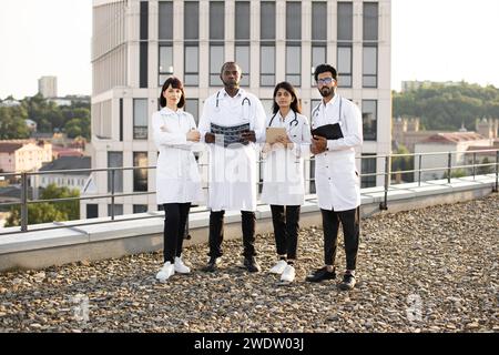 Équipe réussie de médecins multinationaux en blouse blanche avec stéthoscopes Banque D'Images