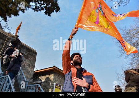 Un dévot hindou tient un drapeau religieux au temple Shankaracharya à l'occasion de la cérémonie de consécration du temple Ayodhya RAM. Lundi après-midi, le Premier ministre Narendra Modi a achevé le « pran pratishtha », ou consécration, du temple RAM à Ayodhya. La cérémonie spéciale pour le temple, qui est encore en construction, a été un effort de plusieurs décennies dans la construction. Pour les hindous, le site marque le lieu de naissance de Lord RAM, l'une des divinités les plus vénérées de la foi hindoue. Mais le site est également vénéré par les musulmans pour avoir abrité la mosquée Babri du 16e siècle, un monument de la foi pour Indi Banque D'Images