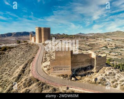 Vue aérienne du château médiéval Jumilla à Murcie Espagne, sur une colline, imposant donjon de forme irrégulière avec quatre étages, créneaux crénelés bl nuageux Banque D'Images