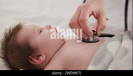 Bébé, stéthoscope et médecin écoutant le cœur, la respiration et tester les soins de santé des enfants en clinique. Nourrisson, rythme cardiaque et main du pédiatre examiner Banque D'Images