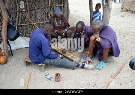 Les hommes de Datooga jouent Mancala. Photographié en Tanzanie. Mancala est l'un des plus anciens jeux connus à être encore largement joué aujourd'hui. Mancala est un nam générique Banque D'Images