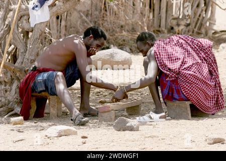 Les hommes de Datooga jouent Mancala. Photographié en Tanzanie. Mancala est l'un des plus anciens jeux connus à être encore largement joué aujourd'hui. Mancala est un nam générique Banque D'Images