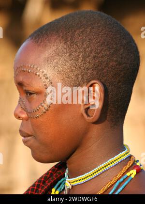 Membres féminins de la tribu Datoga en robe traditionnelle, perles et boucles d'oreilles. Les cicatrices de beauté peuvent être vues autour des yeux, photographiées en Tanzanie Banque D'Images