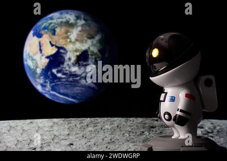 Astronaute dans l'espace regardant le soleil de la surface de la lune et la Terre en arrière-plan. Banque D'Images