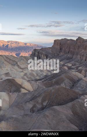 Lever de soleil avec lueur de montagne. Formations rocheuses au premier plan. Zabriskie point, Vallée de la mort Banque D'Images