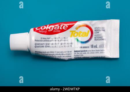 Tube de dentifrice Colgate Total sur fond bleu Banque D'Images