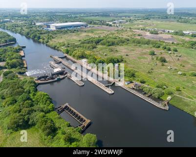 Image aérienne des écluses de Barton sur le Manchester Ship canal avec des champs verts, l'aérodrome de Manchester Barton et Great Bear distribution au loin Banque D'Images