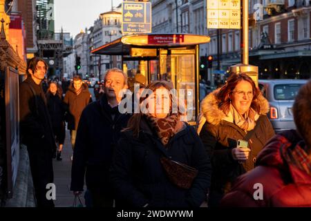 Lumière de fin d'après-midi illuminant les gens marchant le long de Piccadilly le 19 janvier 2024 à Londres, Royaume-Uni. Banque D'Images