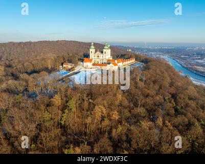 Monastère Camaldolese et église baroque dans le bois sur la colline à Bielany, Cracovie, Pologne, vue aérienne dans la lumière du coucher du soleil en hiver avec la Vistule Banque D'Images