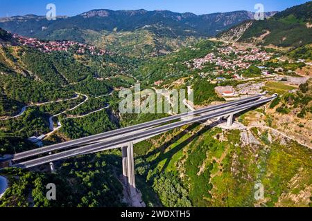 Un des dozes de ponts de la route d'Egnatia. En arrière-plan, la ville de Metsovo (à gauche) et le village d'Anilio (à droite). Ioannina, Épire, Grèce. Banque D'Images