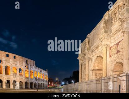 Paysage urbain nocturne de Rome : vue du Colisée et de l'Arc de Constantin, Italie. Banque D'Images