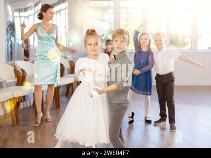 Tween filles ad garçons dansant la danse partenaire lente pendant l'événement festif Banque D'Images