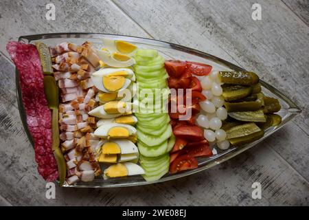 bol doublé plein de nourriture, oeuf, bacon, concombre, salami, tomate, oignon sur un fond de marbre. Banque D'Images