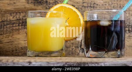 boisson non alcoolisée et jus en verre avec glace et paille sur fond de bois Banque D'Images