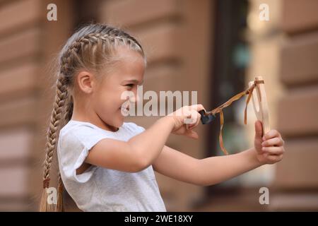 Petite fille jouant avec la fronde sur la rue de la ville Banque D'Images