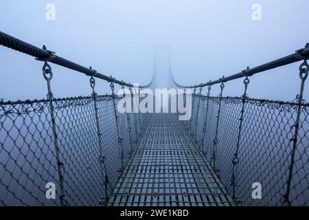 Matin d'hiver brumeux et glacial, pont suspendu. Banque D'Images