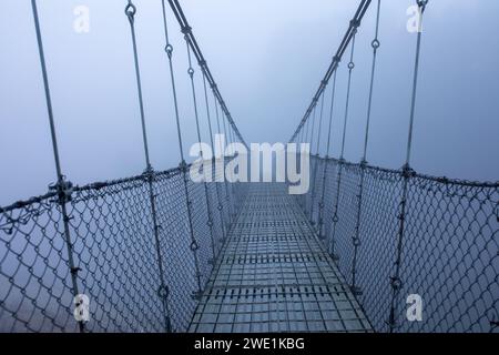 Matin d'hiver brumeux et glacial, pont suspendu. Banque D'Images