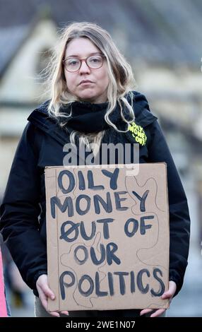 Londres, Royaume-Uni. 22 janvier 2024. Un manifestant tient une pancarte indiquant "de l'argent huileux hors de notre politique" pendant la manifestation. Des manifestants écologistes se rassemblent devant les chambres du Parlement pour protester contre le projet de loi sur les licences offshore. Le projet de loi passe en deuxième lecture aujourd’hui (22 janvier 2024) s’il est adopté, le projet de loi sur les licences pétrolières extracôtières permettra aux sociétés de combustibles fossiles de soumissionner pour de nouvelles licences en mer du Nord chaque année. Les autorités ont déjà annoncé leur intention de délivrer plus de 100 nouvelles licences pétrolières et gazières en mer du Nord. Crédit : SOPA Images Limited/Alamy Live News Banque D'Images