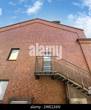 escalier métallique sur mur de briques rouges du bâtiment rénové. sortie de secours sur le mur extérieur. Banque D'Images