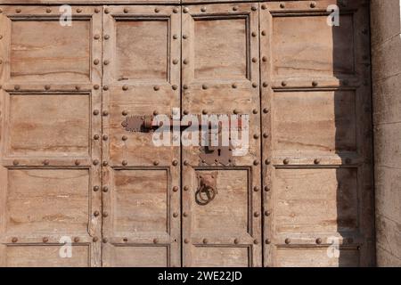 Ferrure de porte en gros plan sur la vieille porte lambrissée en bois dans la rue dans la ville italienne traditionnelle. Banque D'Images