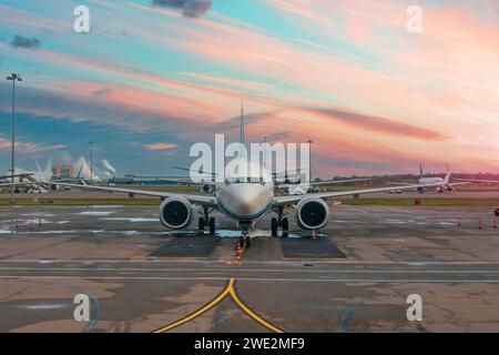 Avions de passagers garés dans le port aérien pendant le ciel de l'aube Banque D'Images