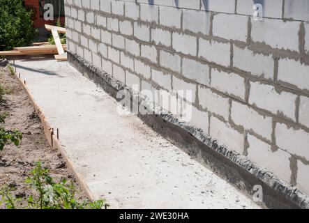 Mur de fondation de maison avec chemin de protection imperméabilisant du béton Banque D'Images